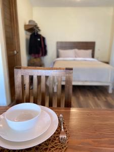 un tazón y un tenedor sobre una mesa con una cama en NIDAL CABAÑAS BOUTIQUE, en La Manzanilla de la Paz
