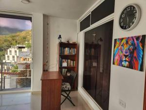 une chambre avec une horloge au mur et une étagère à livres dans l'établissement Loft con espectacular vista a la Bahía de Taganga, à Santa Marta