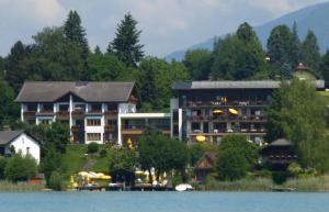 a large hotel on the shore of a lake at Seehotel Ressmann in Drobollach am Faaker See