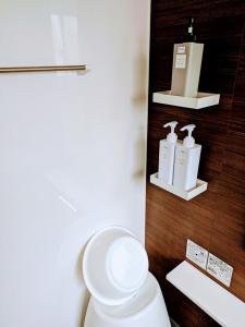 een badkamer met een toilet en 2 flessen zeep bij 書斎でくつろぐスイートルーム in Nagoya