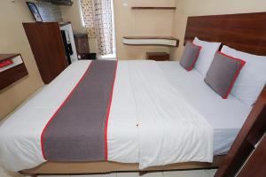 - une chambre dotée d'un grand lit blanc avec des oreillers rouges et gris dans l'établissement Asia Room at Green Lake View Apartment, à Jakarta