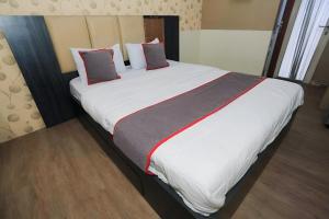 ein Schlafzimmer mit einem großen Bett mit weißer Bettwäsche und Kissen in der Unterkunft Asia Room at Green Lake View Apartment in Jakarta
