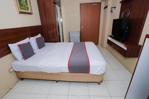 - une chambre avec un grand lit et une télévision dans l'établissement Asia Room at Green Lake View Apartment, à Jakarta