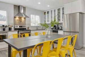 une cuisine avec une table et des chaises jaunes dans l'établissement DFW Stylish Home with Pool Sleeps 9, à North Richland Hills