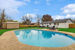 - une grande piscine dans une cour avec une maison dans l'établissement DFW Stylish Home with Pool Sleeps 9, à North Richland Hills