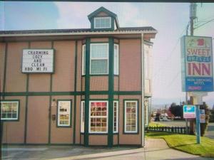 un pequeño edificio con un cartel delante en Sweet Breeze Inn en Grants Pass