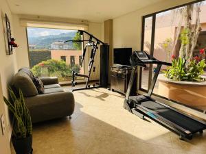 sala de estar con gimnasio con sofá y cinta de correr en Casa de lujo en Paipa Boyacá VIP, en Paipa