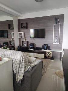 - un salon avec un canapé et une télévision dans l'établissement Apartamento em Canasvieiras, à Florianópolis