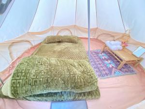 a tent with a bed and a table in it at COI NGUON FARM GLAM Mang Den in Kon Von Kla