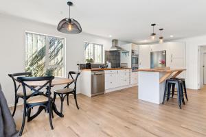 a kitchen with a table and chairs in a room at High Street Pool House in Masterton