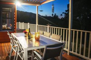 a white table and chairs on a porch with a view at Artee House - A Bright Escape in Bright