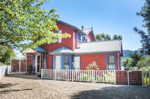 a red house with a white fence in front of it at Artee House - A Bright Escape in Bright