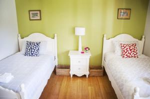 a bedroom with two beds and a table with a lamp at Artee House - A Bright Escape in Bright