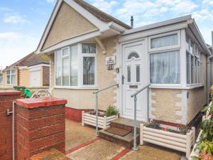 a house with a white door and a brick wall at The Bungalow in Rhyl