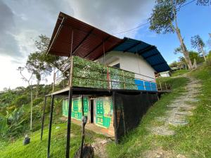 um pequeno edifício com um telhado numa colina em Hotel Glamping Horse em Dosquebradas