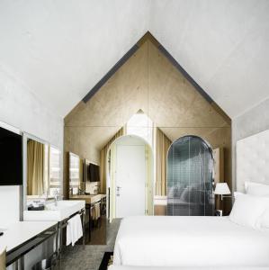 een slaapkamer met 2 bedden en een badkamer met een wastafel bij M Social Singapore in Singapore