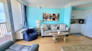 una sala de estar con un sofá y una mesa en Sunkissed-Modern Oceanfront Condo Daytona Beach, en Daytona Beach