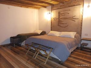 ein Schlafzimmer mit zwei Betten und einem Gemälde an der Wand in der Unterkunft EL Viejo Algarrobo Fiambala in El Puesto + 36 Fotos