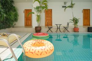 una piscina con 2 sillas y una rosquilla. en Nonnee Hotel Kata Beach Phuket, en Kata Beach