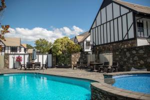 a swimming pool in front of a house at Scenic Hotel Cotswold in Christchurch