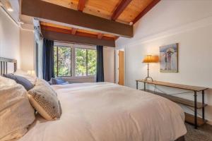 a bedroom with a large white bed and a window at Lake Views, Decks, Private HOA Beach, Pool, Hot-Tub, Courts, and More Seasonal Amenities in Tahoe City +25 photos