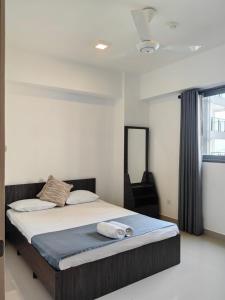 una camera da letto con un letto e due asciugamani di Stayz by Gentz Residency a Colombo