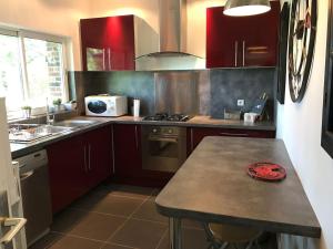 una cocina con armarios rojos y una mesa. en Maison de 3 chambres a Annebault, en Annebault