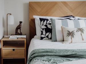 a bedroom with a bed with a wooden headboard and pillows at Mountview Alpaca Farmhouse in Canungra