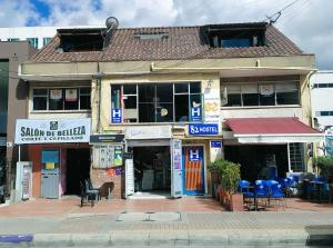 a building on a street with blue tables and chairs at 82Hostel in Bogotá