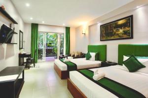 Habitación de hotel con 2 camas y sala de estar. en Ra-Ta Boutique Hotel, en Siem Reap