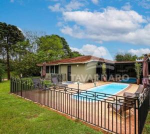 uma casa com uma cerca em redor de uma piscina em Aconchego e natureza em PG em Ponta Grossa