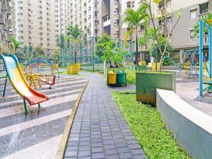 einen Park mit Spielplatz mit Rutsche in der Unterkunft Blossom Suites Bandung Cicadas at Gateway Apartment in Bandung