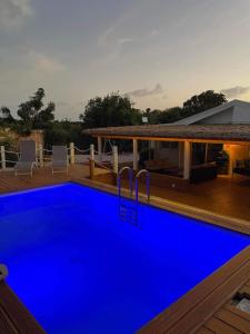 a blue swimming pool in front of a house at Coco Lodge in Les Terres Basses