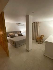 sypialnia z łóżkiem i krzesłem w obiekcie Coco Lodge w mieście Les Terres Basses