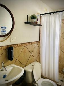 y baño con aseo, lavabo y espejo. en Cozy PH Apartment in the City en Guatemala