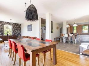 una sala da pranzo e un soggiorno con tavolo e sedie di Élégante maison à Vichy : piscine chauffée, jardin arboré, terrasse et climatisation - FR-1-489-494 a Vichy