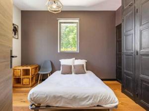 una camera da letto con un letto e una finestra di Gîte de charme avec piscine chauffée près des thermes de Vichy, jardin clos, clim et confort absolu - FR-1-489-495 a Vichy Altre 13 foto