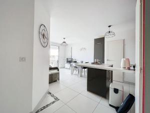 a kitchen and dining room with a clock on the wall at Appartement Palavas-les-Flots, 3 pièces, 5 personnes - FR-1-715-94 in Palavas-les-Flots
