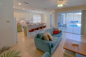 un salon avec un canapé bleu et une cuisine dans l'établissement Family Vacation House at Resort, à Kissimmee
