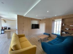 uma sala de estar com um sofá amarelo e cadeiras azuis em Villa Vieux-Boucau-les-Bains, 6 pièces, 10 personnes - FR-1-379-168 em Vieux-Boucau-les-Bains