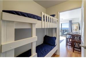 Habitación con 2 literas y 1 silla en 327 Breakers 1 BR Oceanview Forest Beach, en Hilton Head Island
