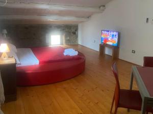 ein Schlafzimmer mit einem großen roten Bett in einem Zimmer in der Unterkunft Il Casale in Marano Marchesato