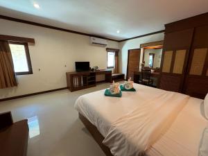 Beach Bungalow at Lanta Resort في كو لانتا: غرفة نوم عليها سرير وفوط