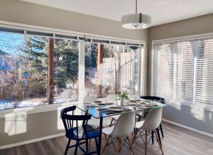 a dining room with a table and chairs and windows at Private, Spacious, & Bright Home in Calgary