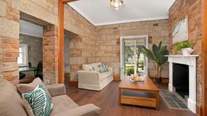 uma sala de estar com uma parede de tijolos em Loch Lomond Lodge em Mittagong