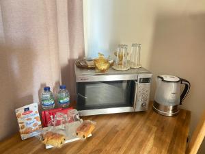 a microwave sitting on top of a wooden floor at Upton Country Park Guest House in Northampton