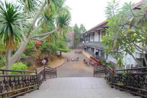 - une vue sur une rue bordée de palmiers et un bâtiment dans l'établissement Sinergi Hotel Tretes, à Pasuruan