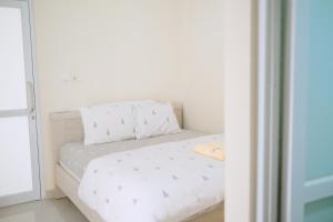 a bed with white sheets and pillows in a room at Kays Homestay Jogja in Ngemplak +19 photos