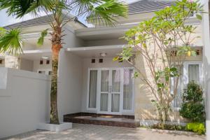 a house with palm trees in front of it at Kays Homestay Jogja in Ngemplak