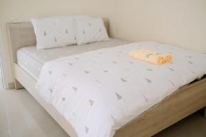 - un lit avec un couvre-lit blanc et un oreiller dans l'établissement Kays Homestay Jogja, à Ngemplak